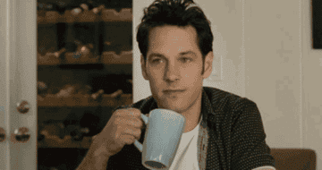 Paul Rudd nodding with a cup of coffee in hand 