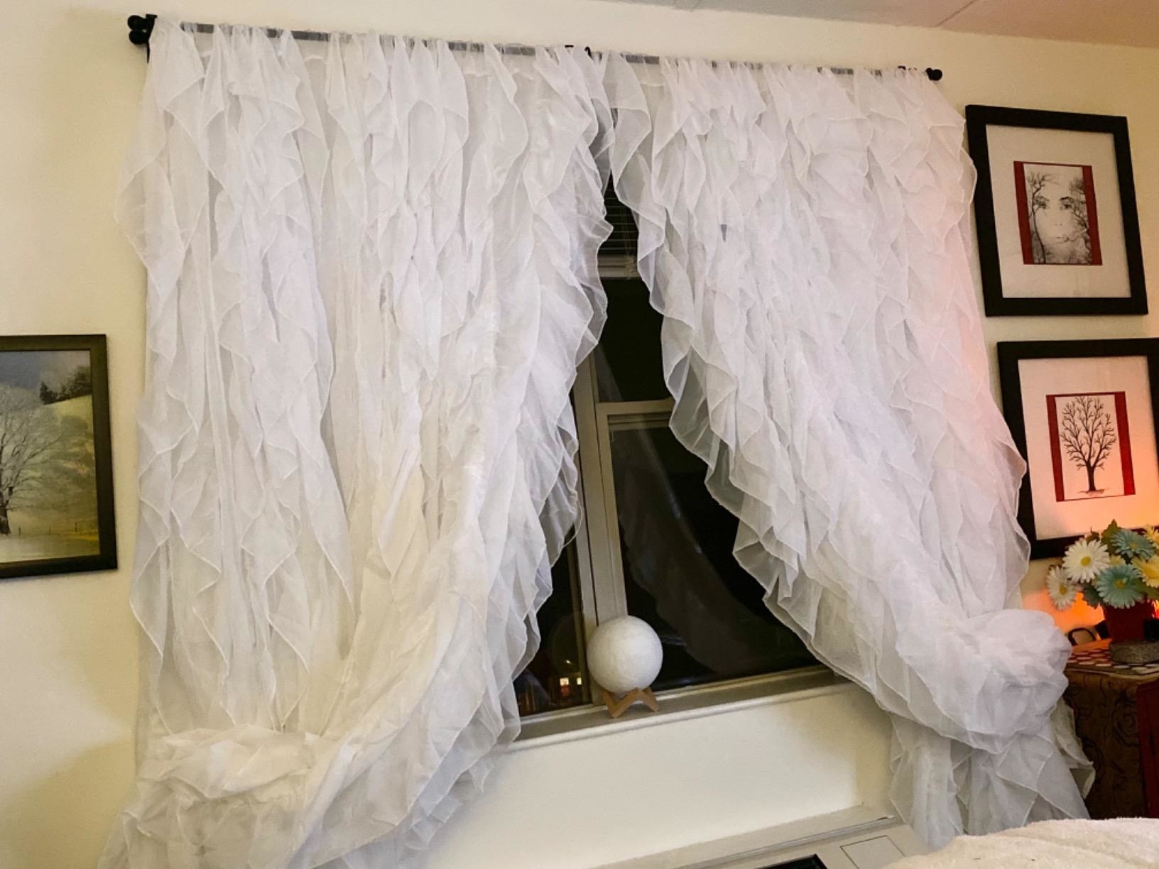 reviewer image of the white diamond home cascade sheer curtains hanging from a bedroom window