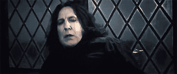 Nagini leaps at Snape, who is backed up against a wall