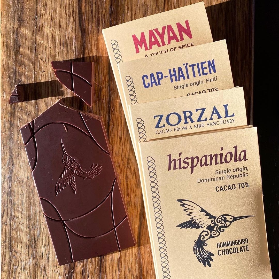 A set of four artisanal chocolate bars on a wooden counter