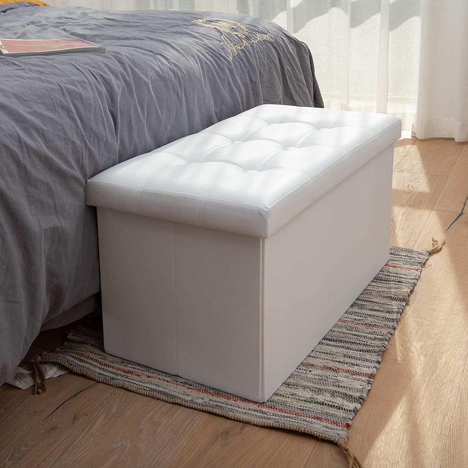 The ottoman at the end of a bed on a carpet