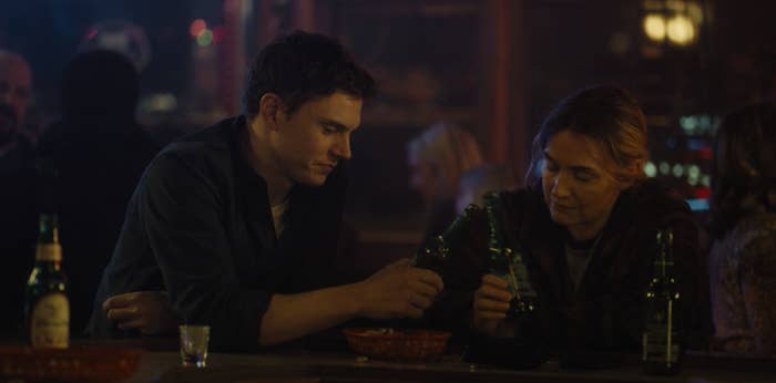 Evan Peters and Kate Winslet toasting at the bar