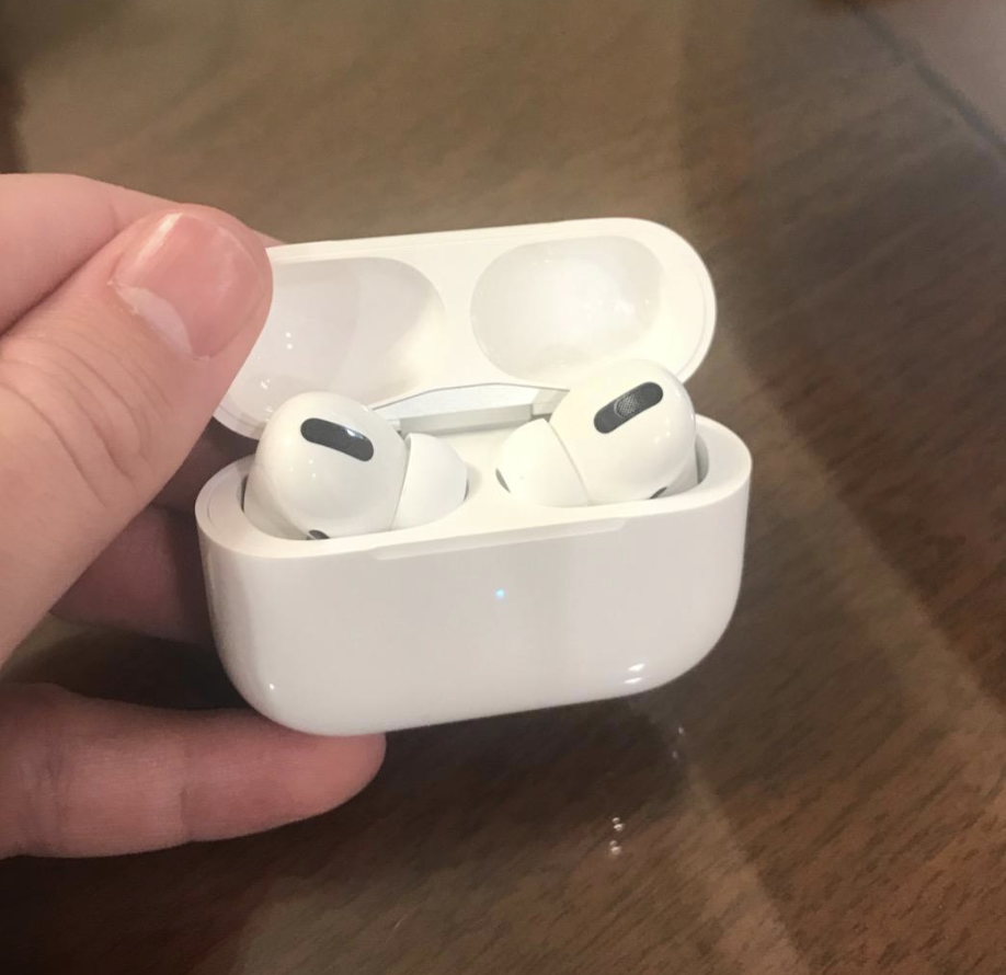 Reviewer holding AirPods Pro in their charging case 