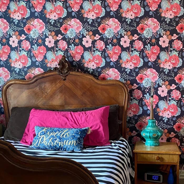 reviewer image of the floral peel and stick wallpaper on a bedroom wall