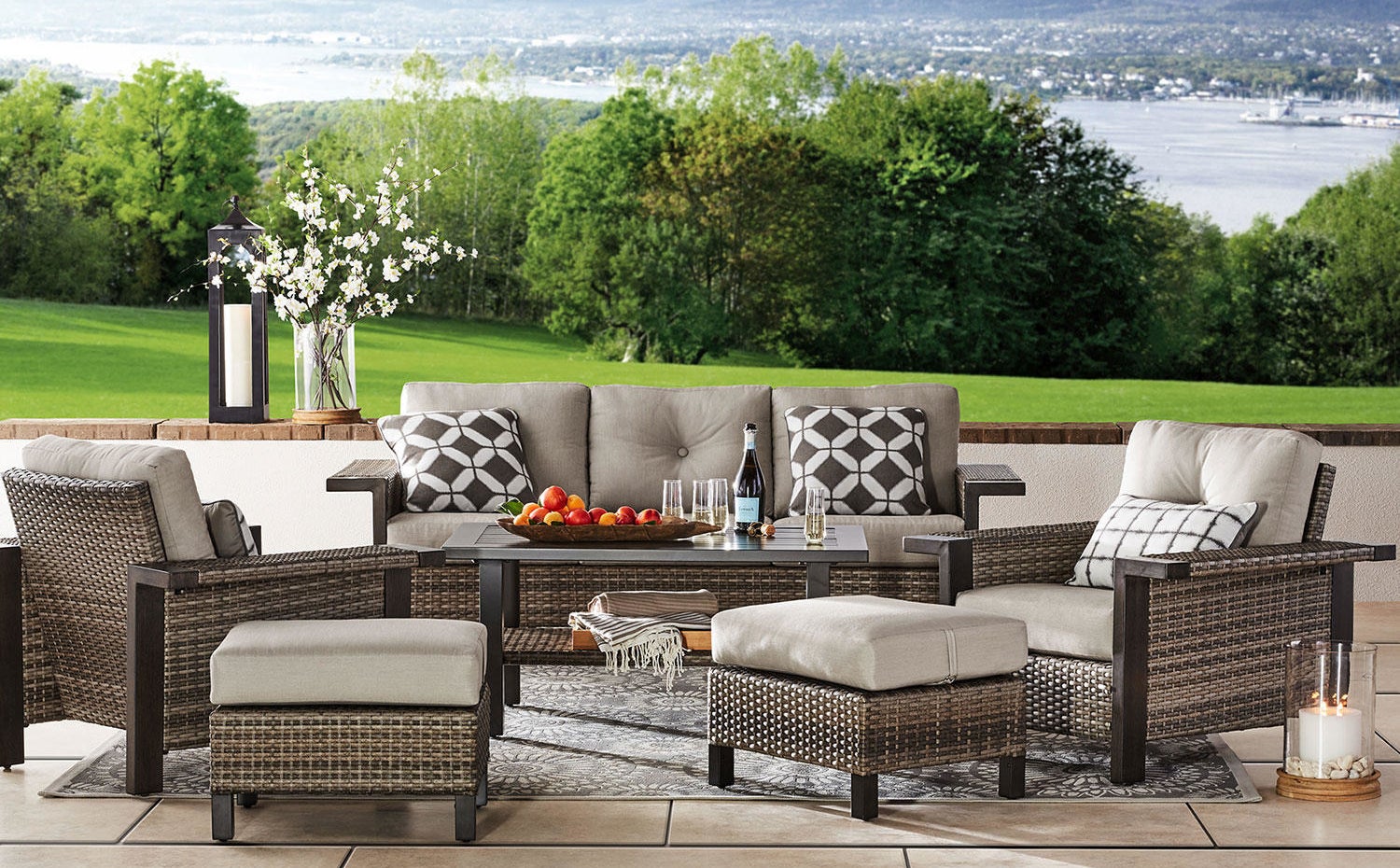 A wicker outdoor furniture set with two stools, two chairs, a table, and a couch