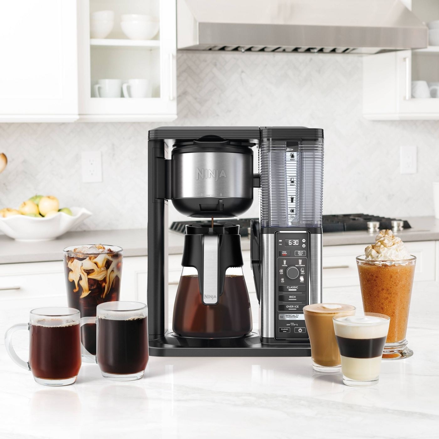 A specialty coffee maker on a kitchen counter surrounded by coffee drinks