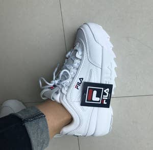 Reviewer wearing chunky white Fila sneakers