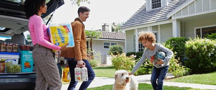 family unloading groceries from car