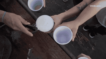 Someone filling plastic cups with beer