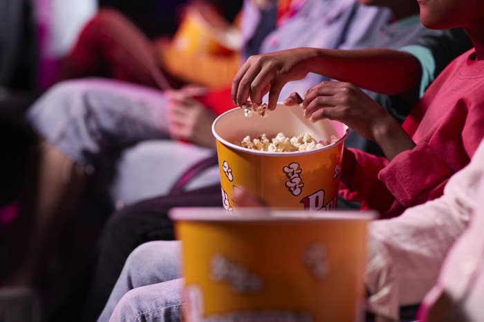 People eating popcorn at a movie theater.