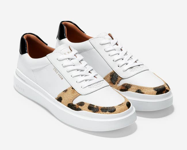 the white sneakers with strip of leopard print around the toe and black by the heel