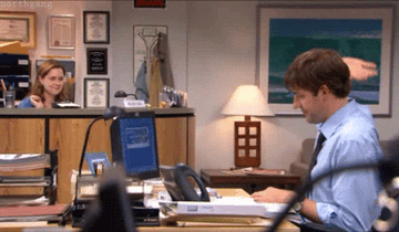 Jim and Pam high-five each other from across the office