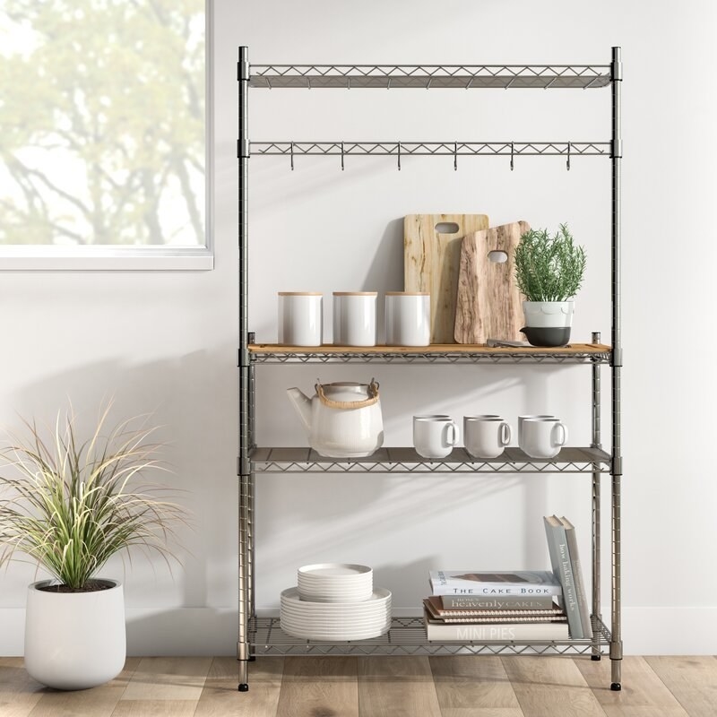 the rack with plates, cups, cutting boards and other kitchen accessories