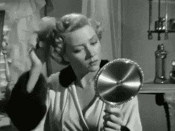 Gloria Grahame doing her hair in a scene from In A Lonely Place 