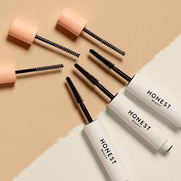 Three open tubes of Honest Mascara flat laying down
