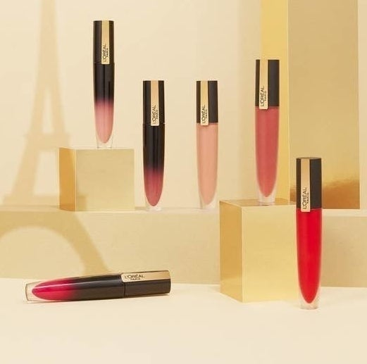Six tubes of L&#x27;Oreal Lip stain posed near shadow of Eiffel Tower 