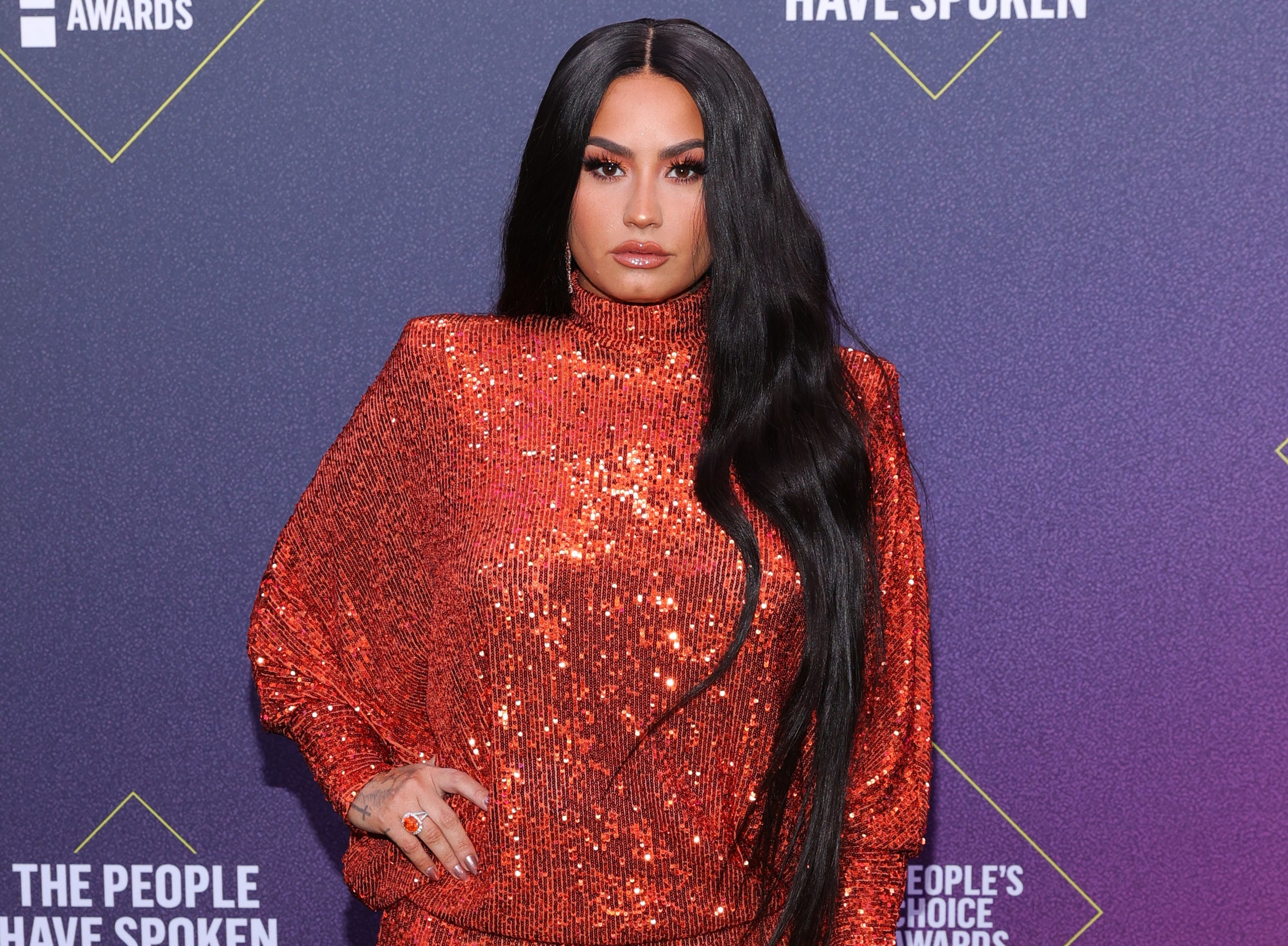 Demi wears a sparkling red jumpsuit at an event