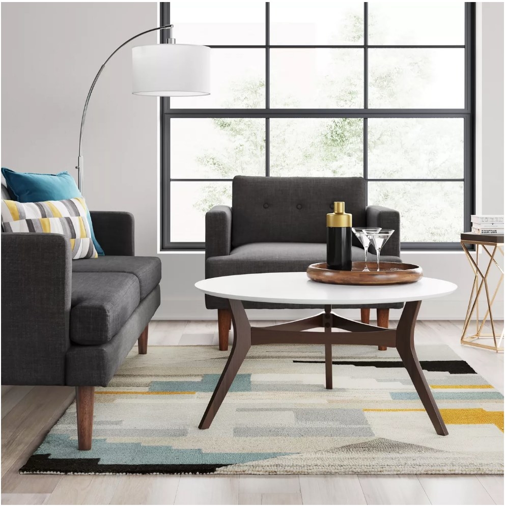 A blue, gray, black, and yellow abstract area rug displayed in a living room