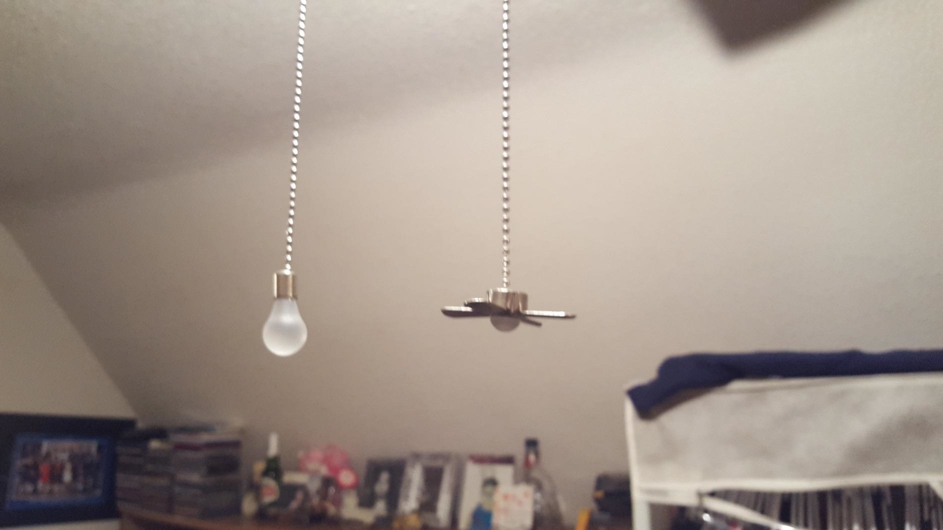 reviewer photo of pull chains (one shaped like light bulb, one shaped like fan) hanging from fan