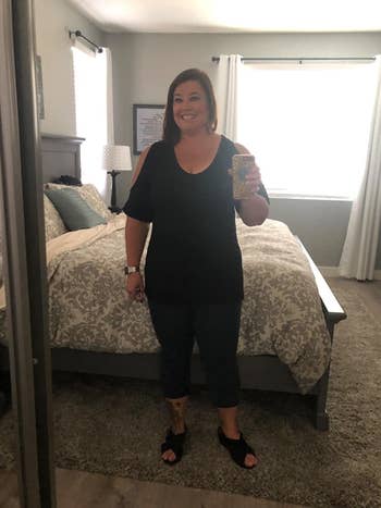 image of reviewer wearing the black cold shoulder top with leggings 