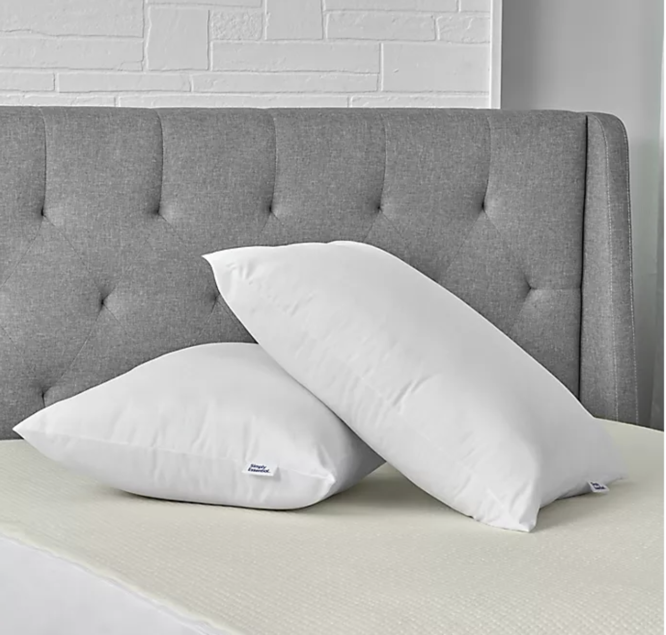 Two white microfiber pillows on a bed 