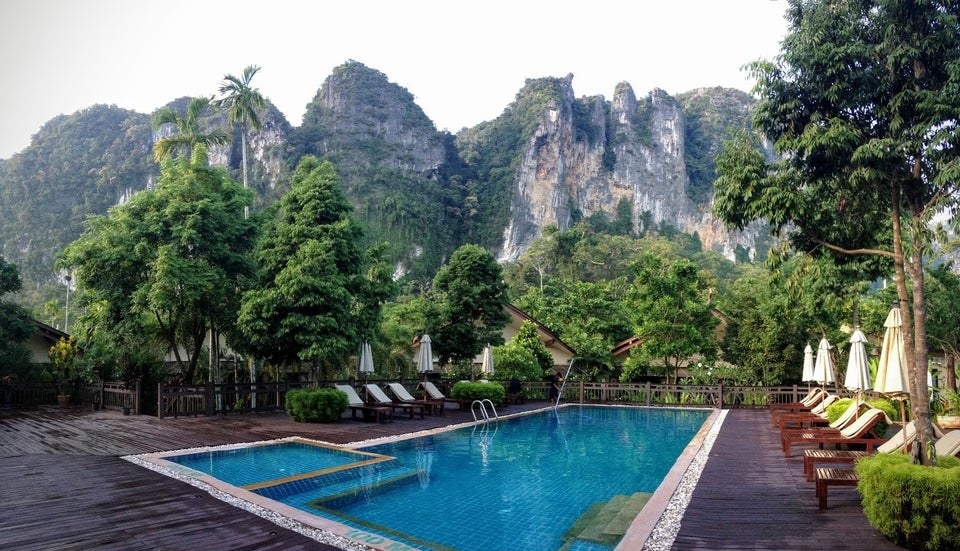 A hotel pool view with a mountainous backdrop in Ao Nang, Thailand