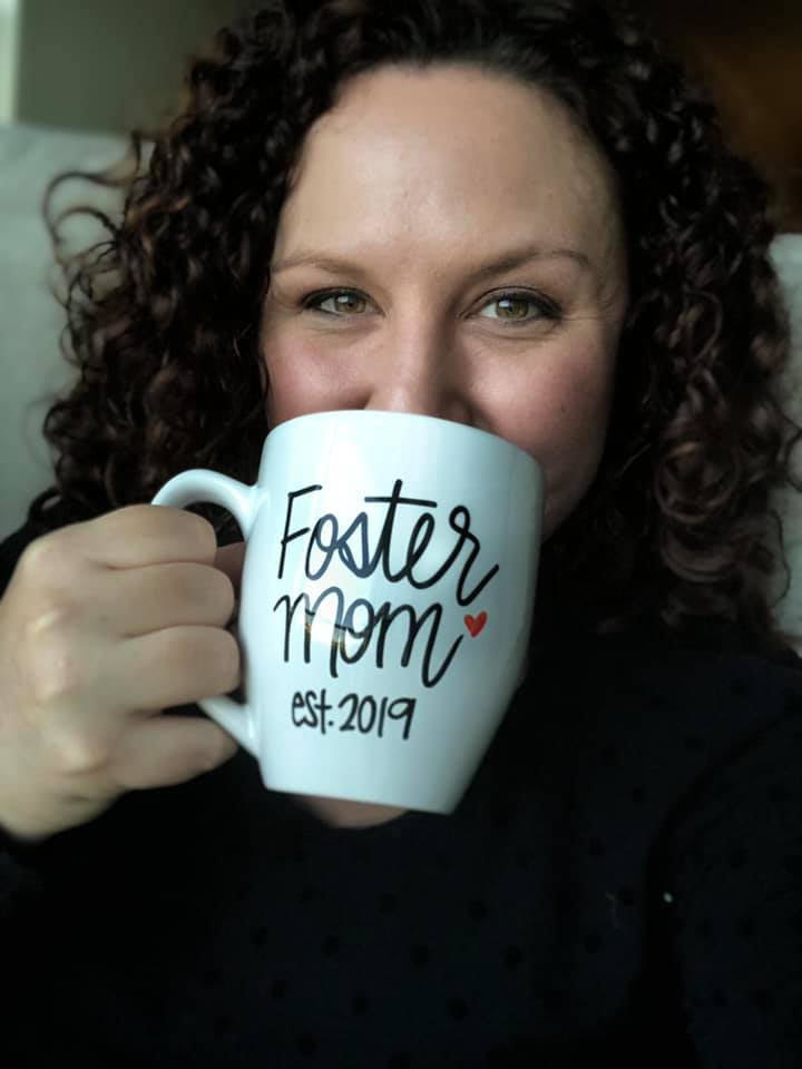 Brittany holding a mug that says &quot;Foster mom est. 2019