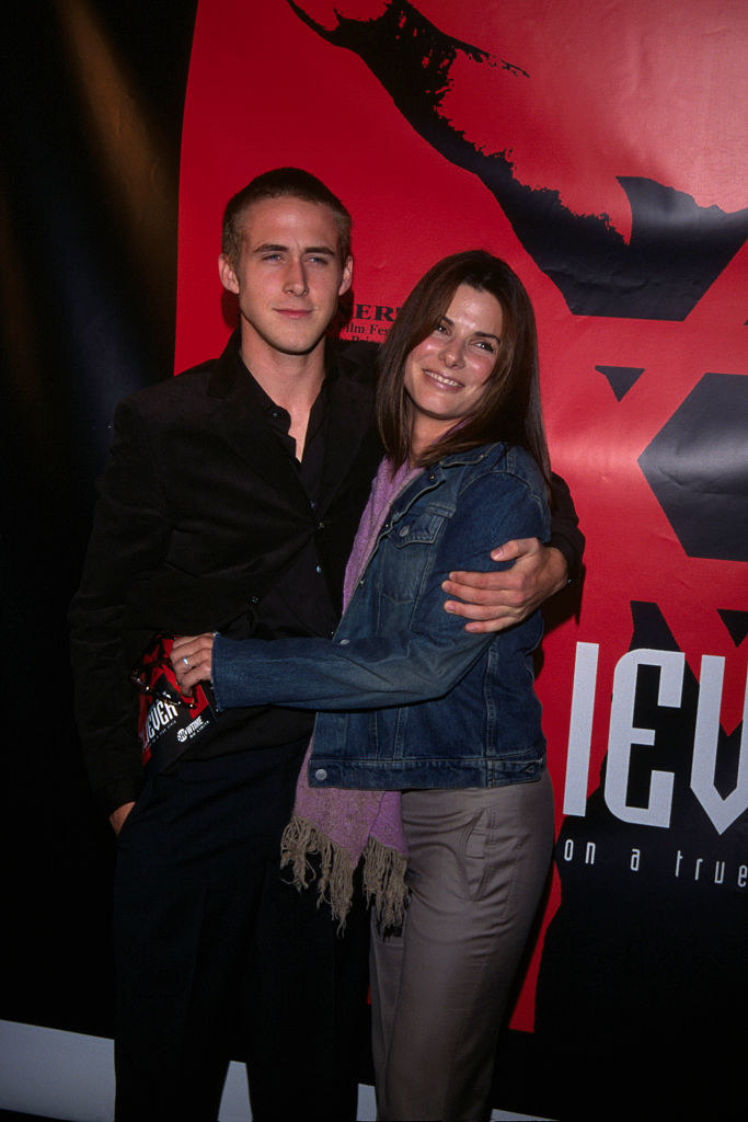 Sandra Bullock with her arms wrapped around Ryan Gosling