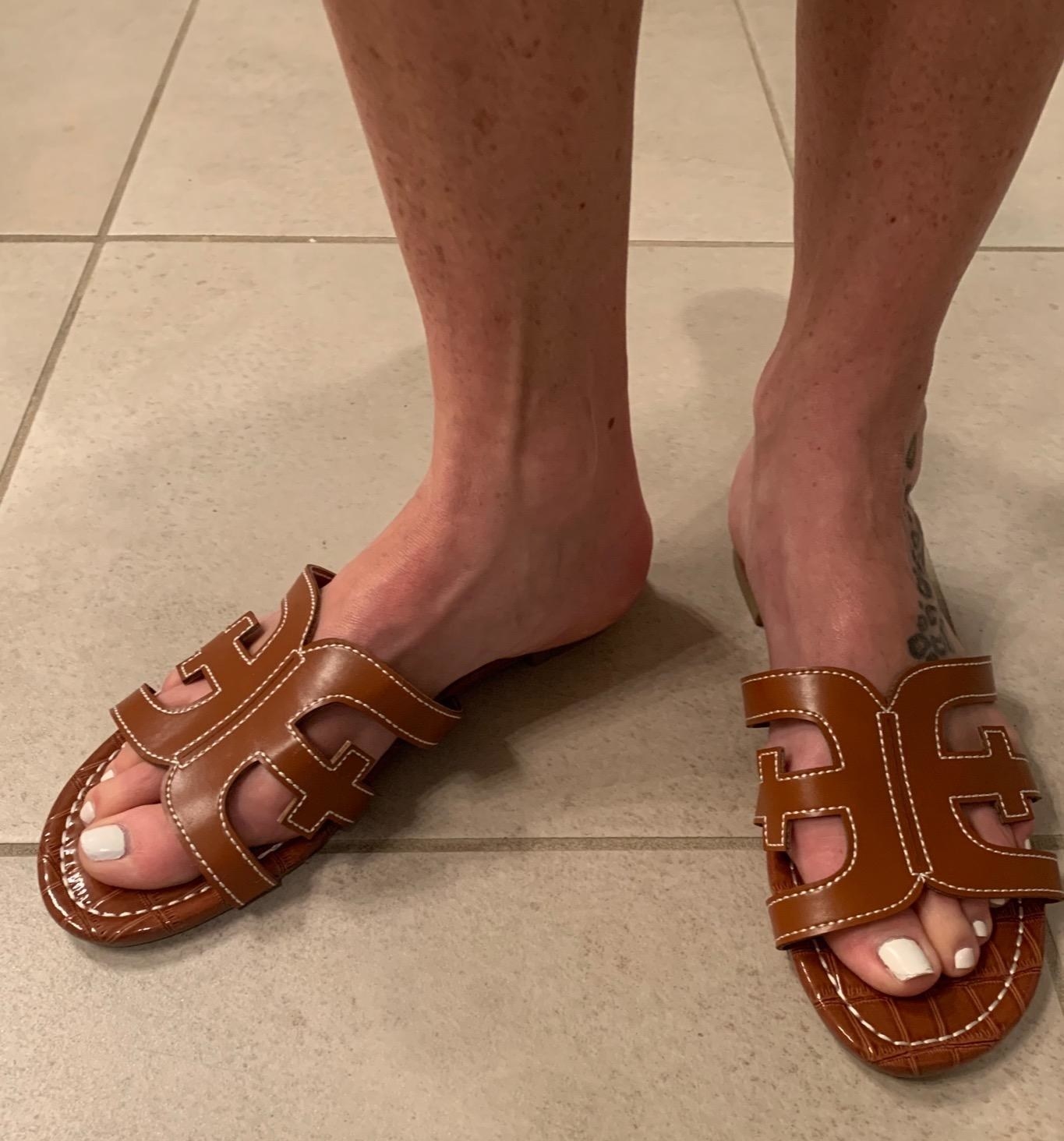 reviewer wearing the cut-out slip-on sandal in brown