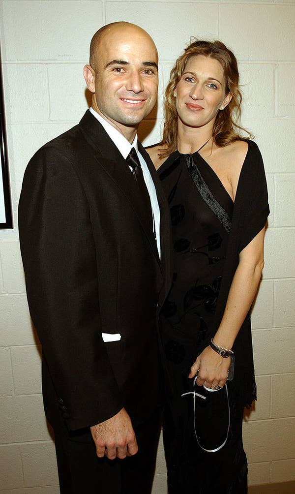 Andre Agassi and Steffi Graf standing in front of a cinderblock wall