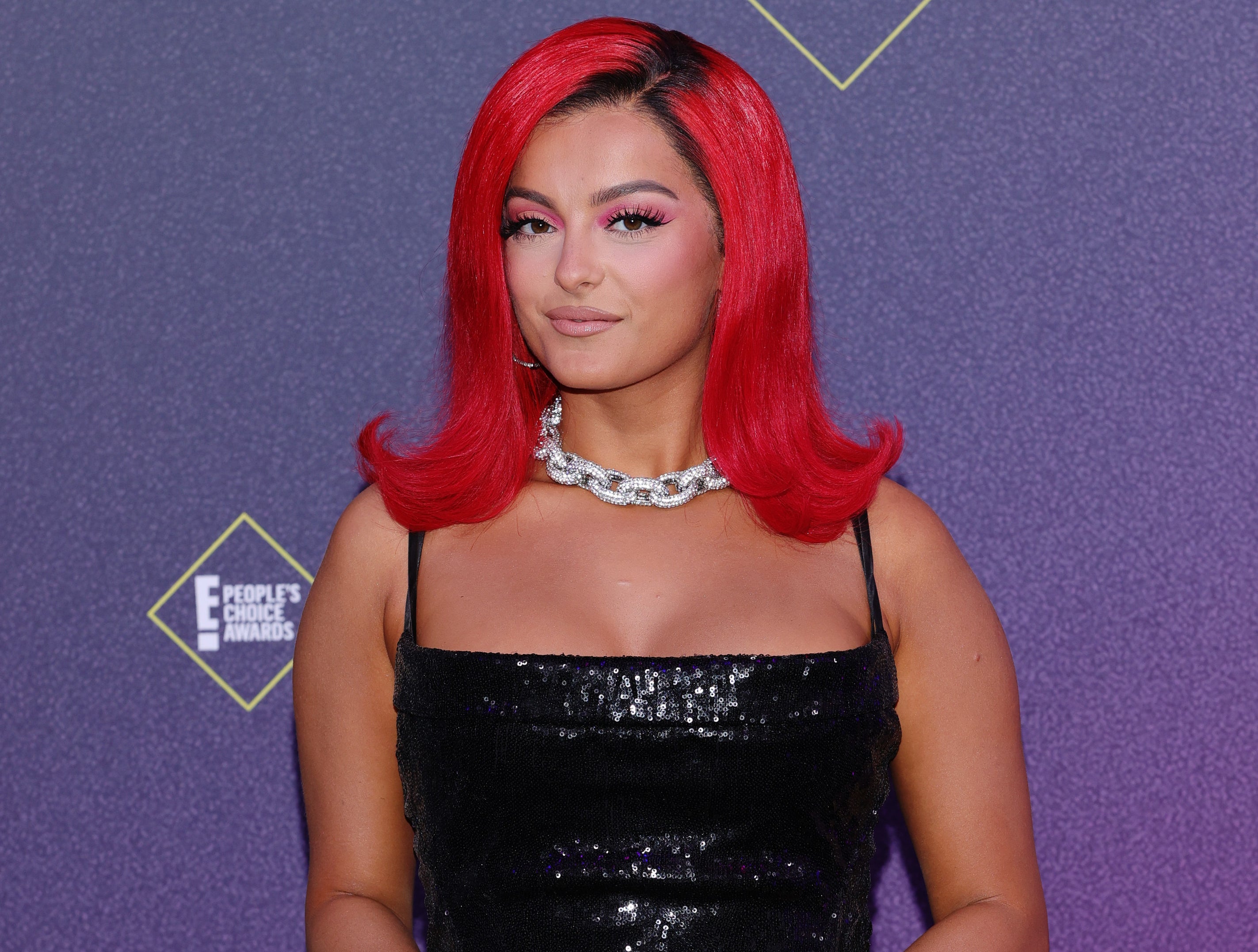 Bebe&#x27;s red hair is flipped out at the shoulders while she wears a black sequined dress