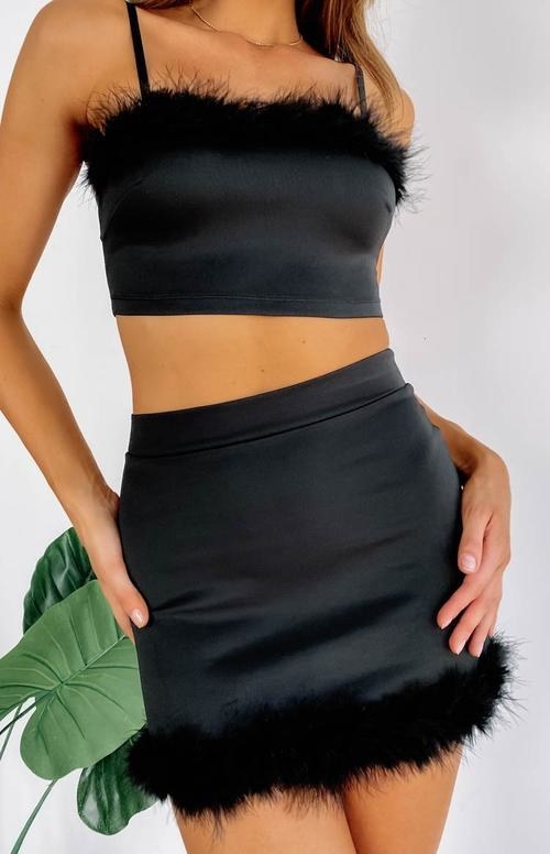 close up of model wearing the black annette top with matching skirt