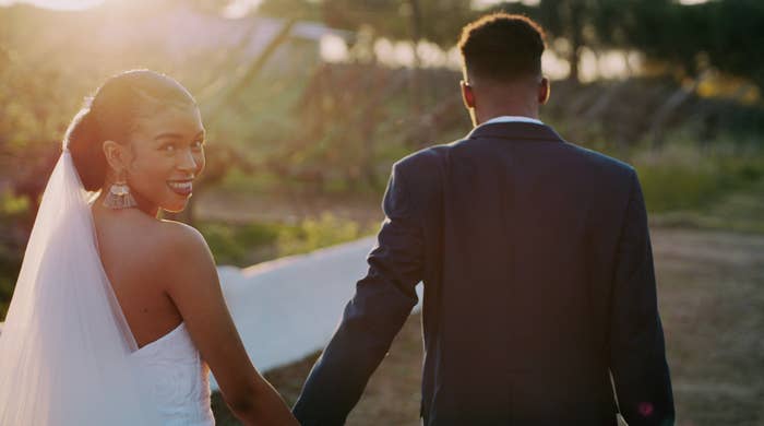 Portrait of a young newlywed couple holding hands and walking outside on their wedding day