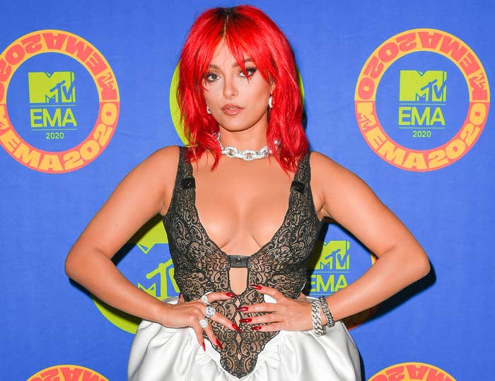 Bebe has short red hair while wearing a sheer lace dress at an awards ceremony
