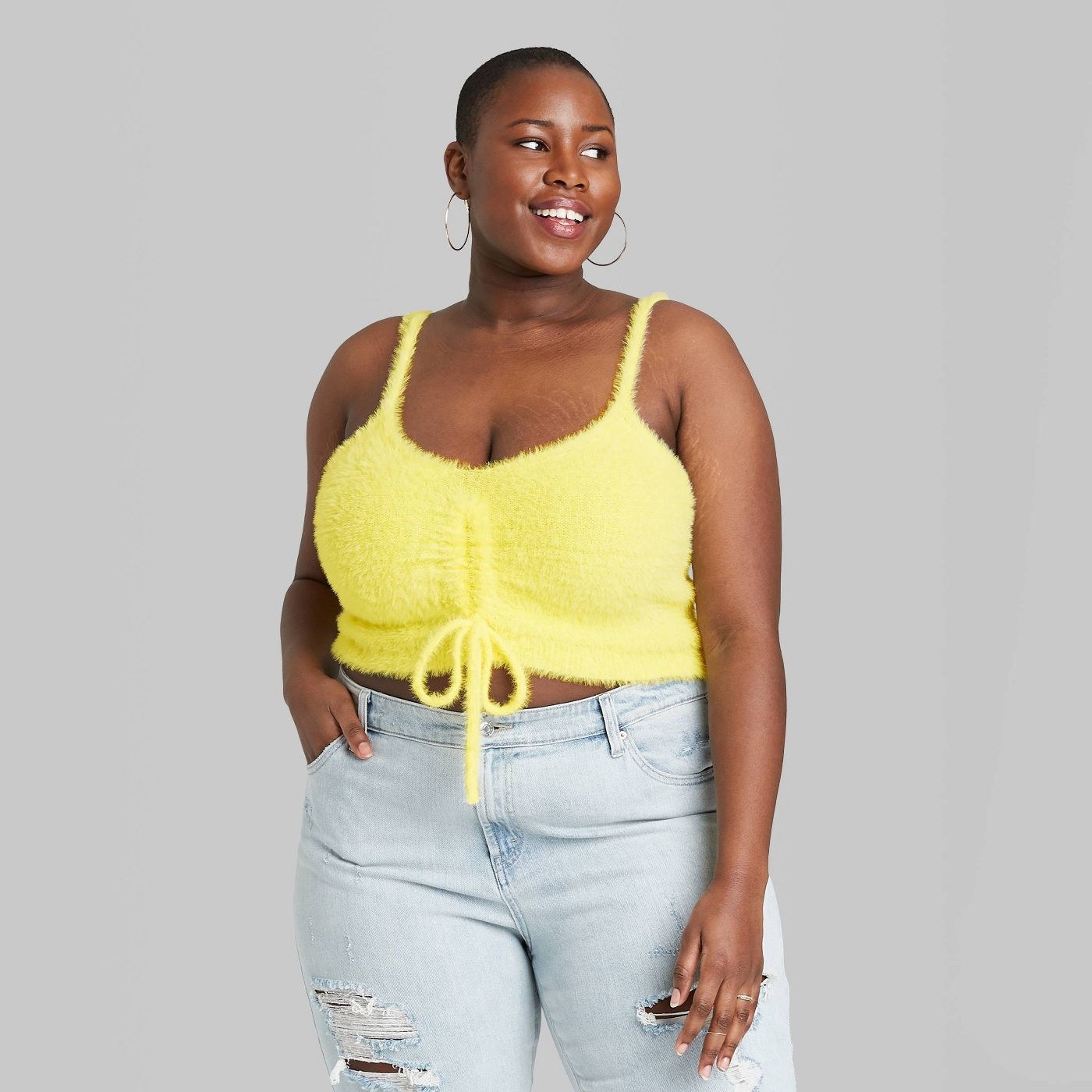 a plus size model wearing the yellow ruched fuzzy top