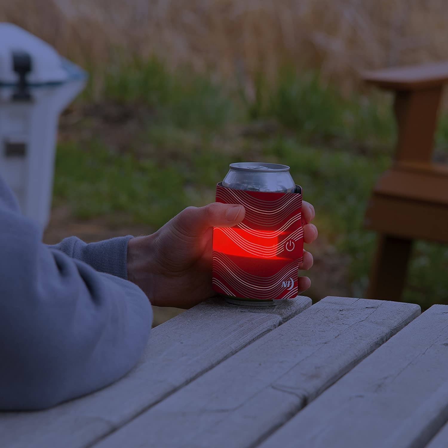 A person holding their drink with the light-up holder on it