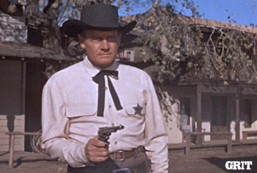A cowboy puts a gun in his holder