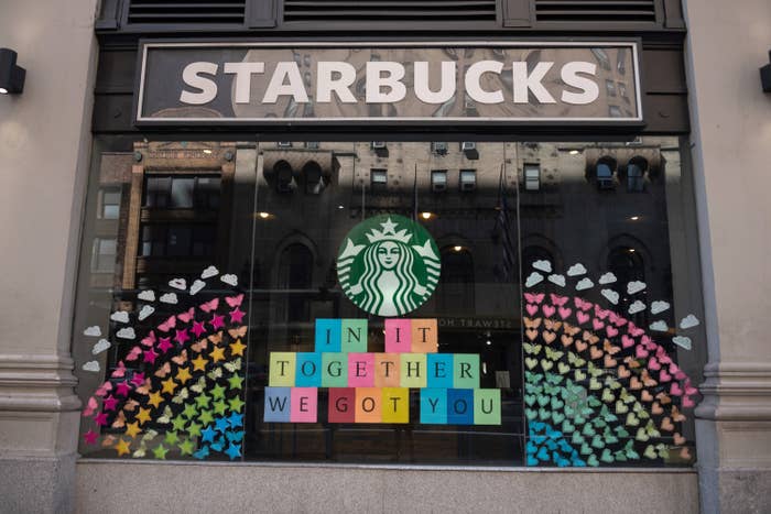 A Starbucks window displays a sign reading &quot;In it together, we got you&quot;