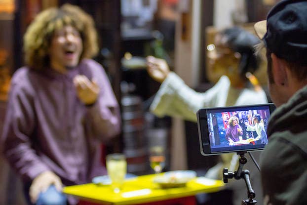 Man recording man and women at table in Japan