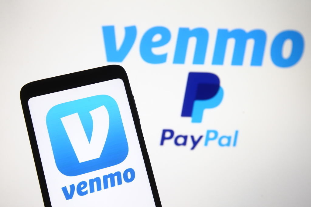 手机上有Venmo，手机后面的墙上有Venmo PayPal