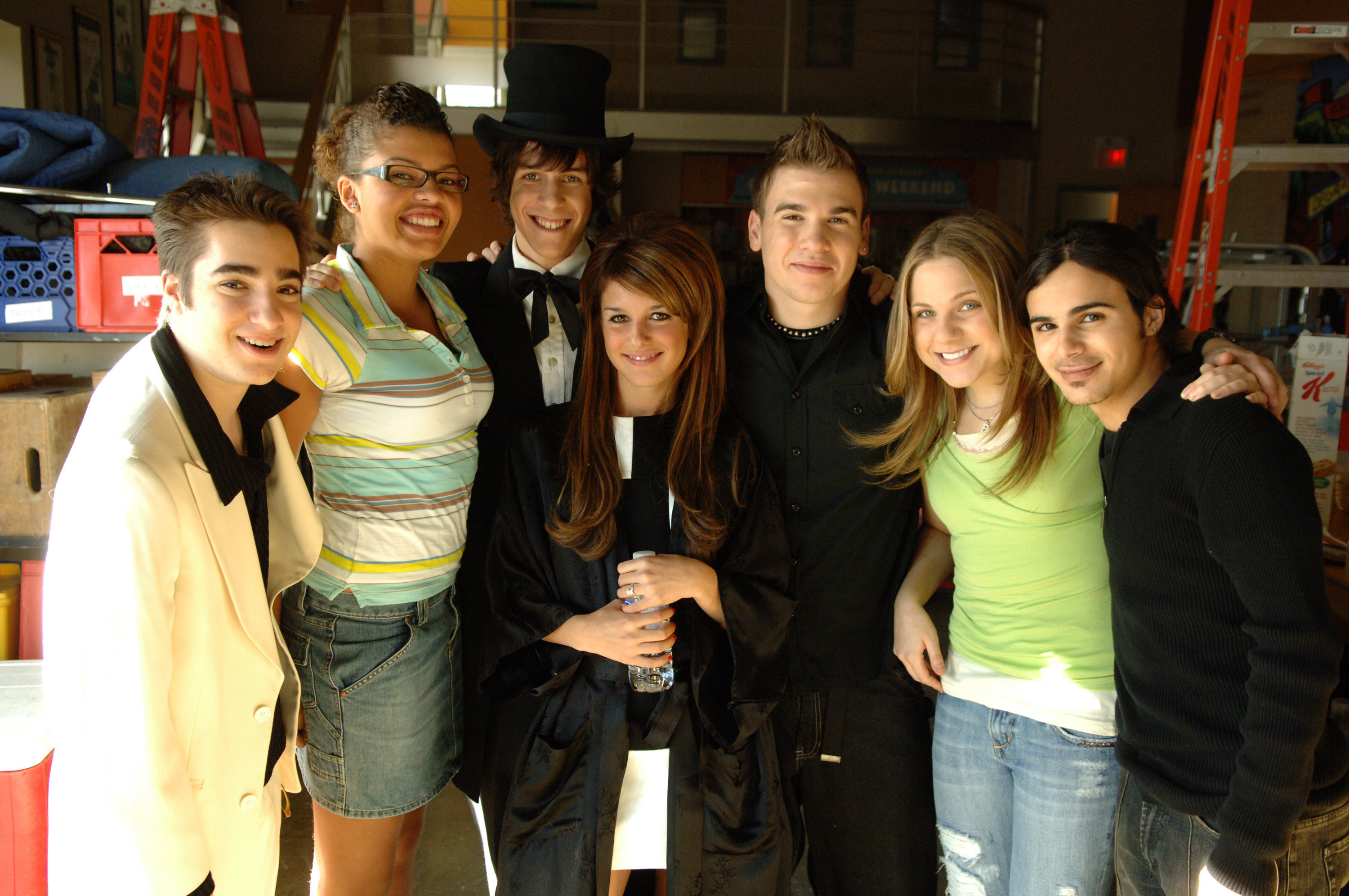 A portion of the cast pose for a photo on set