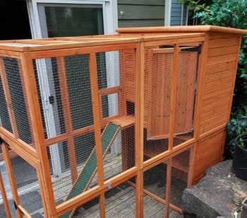 A reviewer photo of the cat patio, which is wooden and open, with mesh covering the top and sides