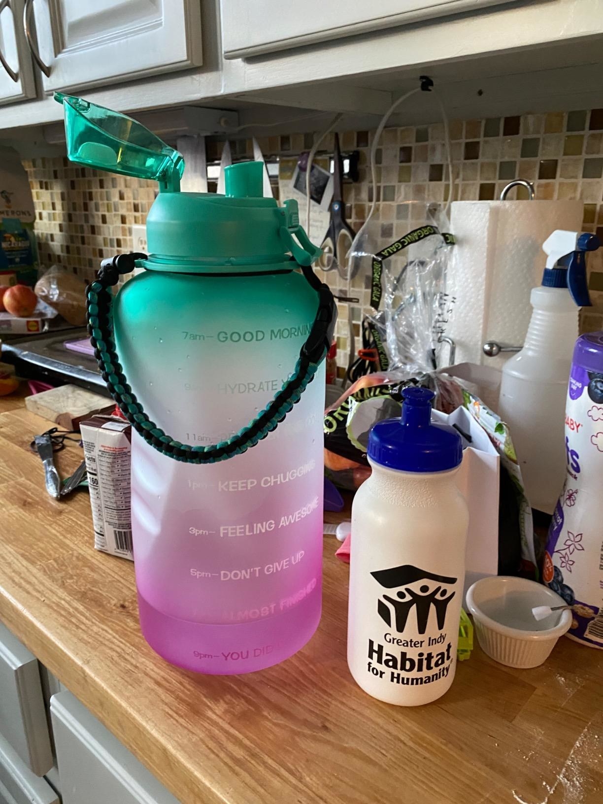A reviewer compares the teal and purple ombre product to a normal-sized water bottle, which is much smaller. Affirmations include &quot;feeling awesome,&quot; &quot;don&#x27;t give up,&quot; and &quot;keep chugging&quot;