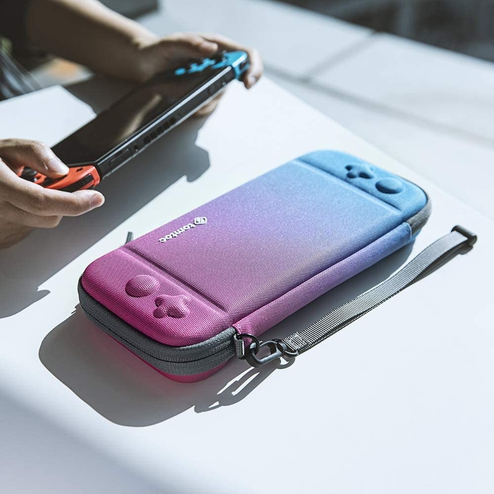 The case on a table in front of a person playing with their Switch