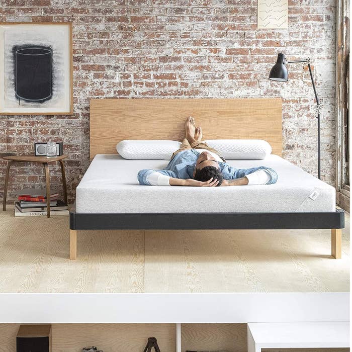 model lying on mattress with feet on pillows