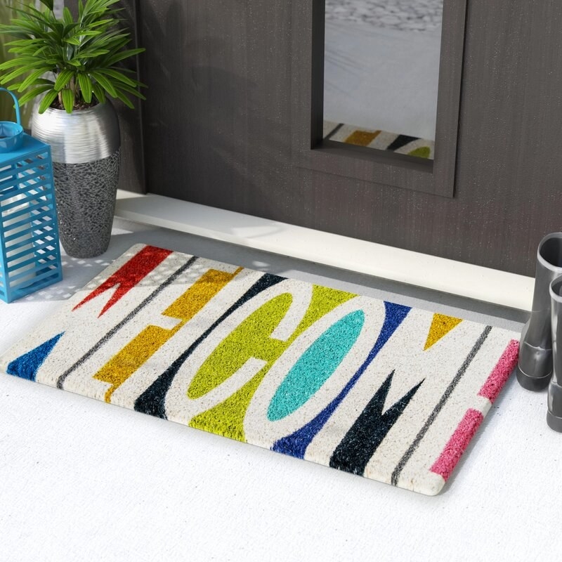rainbow-tone doormat that says "welcome" in block white lettering