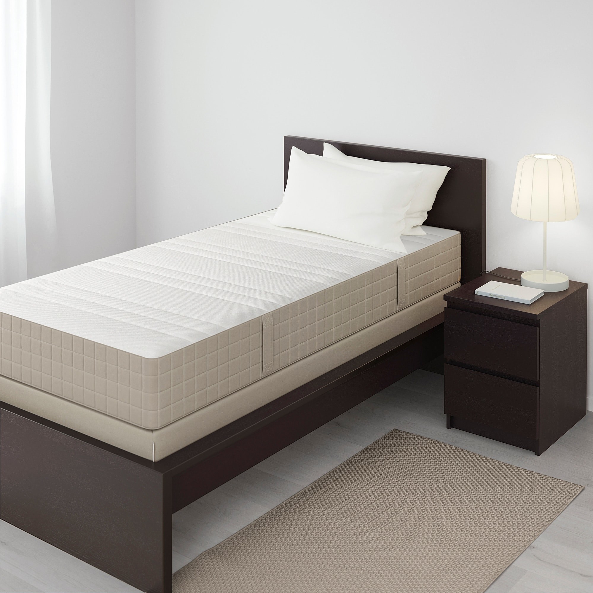 the mattress on a brown bed frame with pillows on top and a nightstand to the right