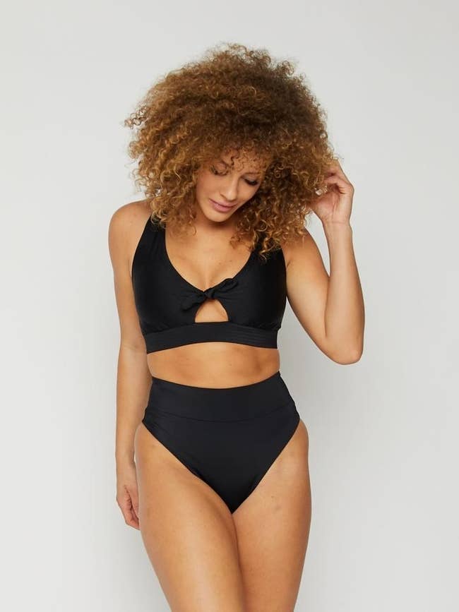 Model wearing black bathing suit, front