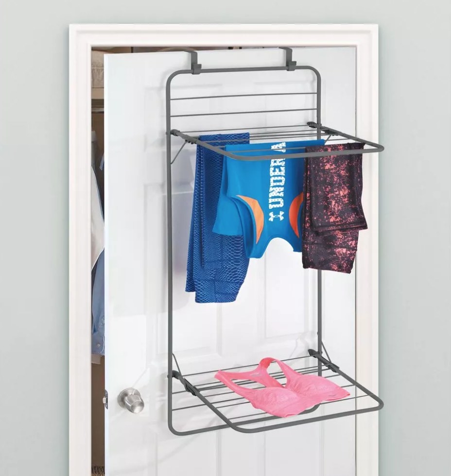 Drying rack over the door with clothes on top and bottom shelf 