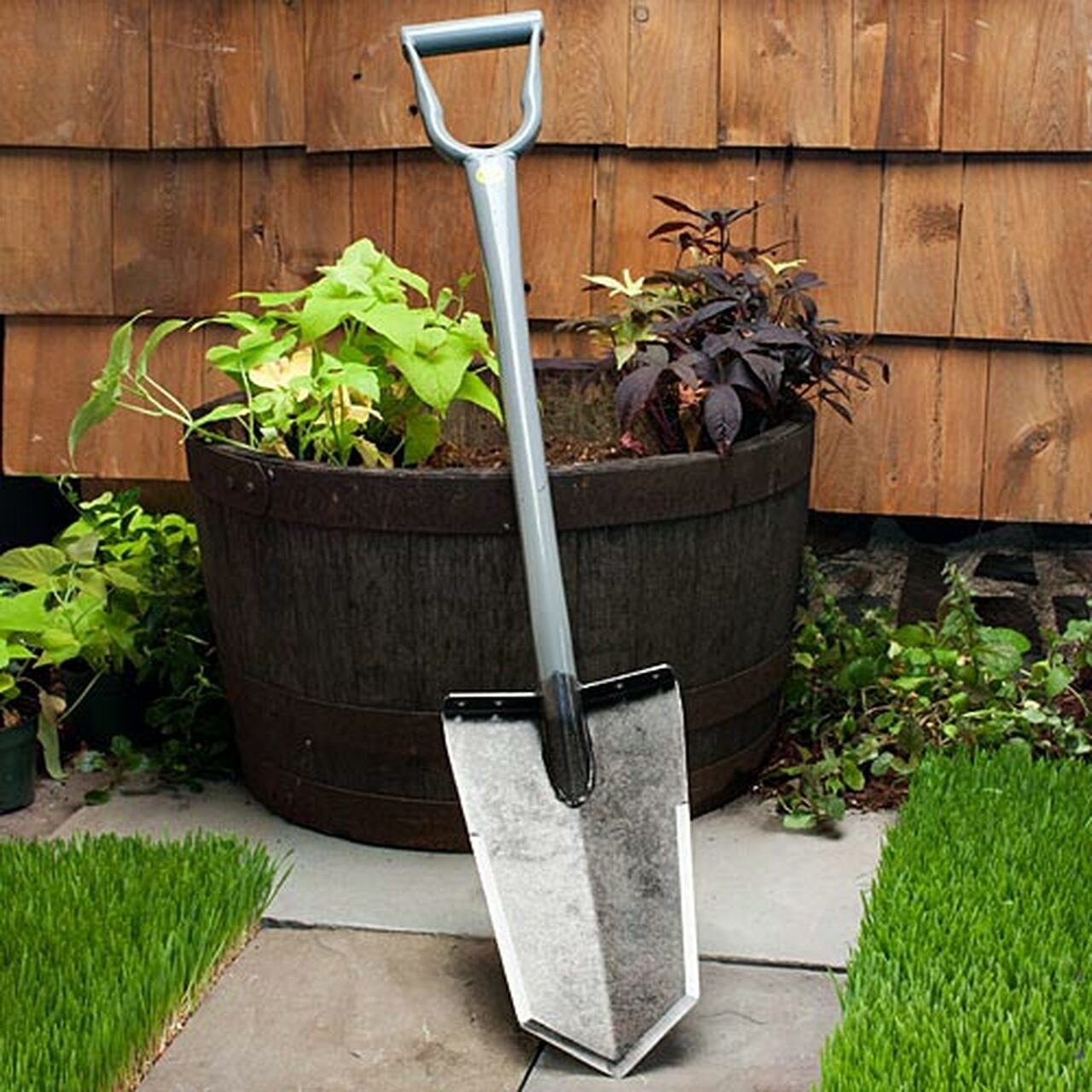 the all-steel shovel leaning against an outdoor planter